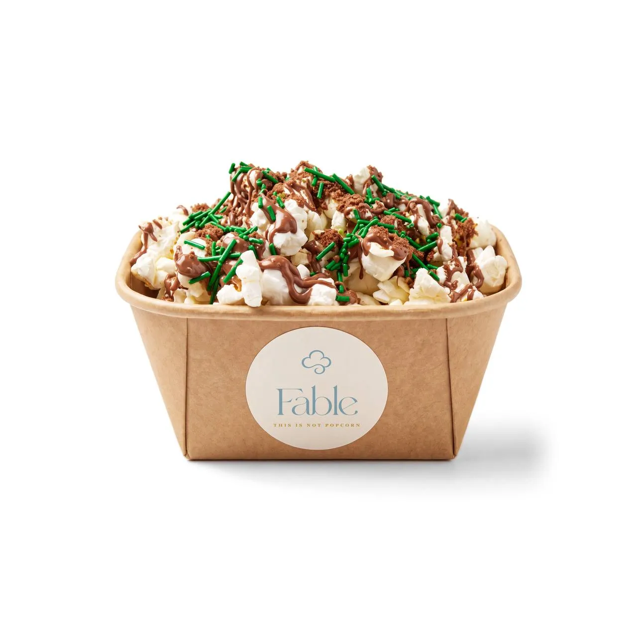 A kraft Fable tub of Dinosaur Crunch popcorn with a brown drizzle, a dark crumble and bright green sprinkles.